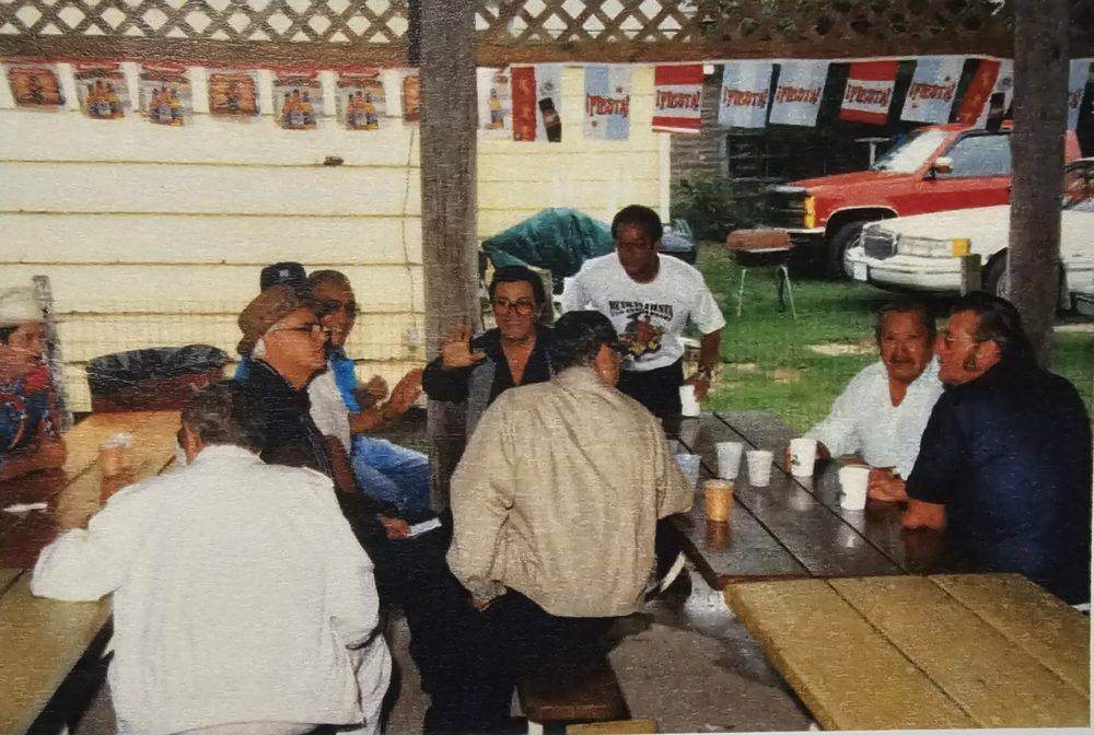 Archival photo of a gathering at the Hospitality Tent, decorated with Fiesta banners